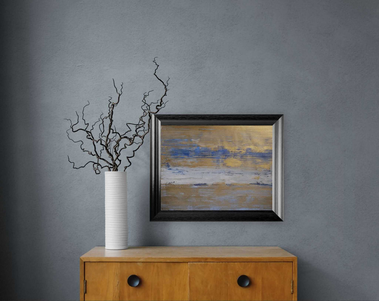 peinture acrylique paysage abstrait dans un cadre sur un meuble en bois, décor moderne, couleurs bleu et or.